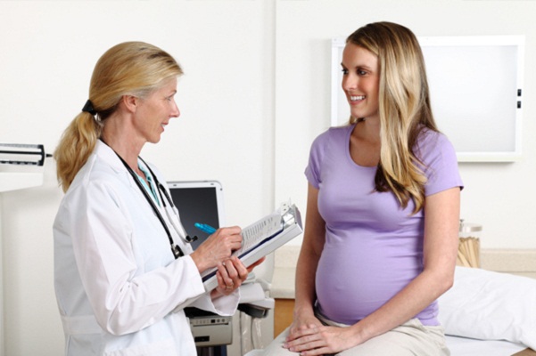 pregnant woman consulting with doctor about flu shot